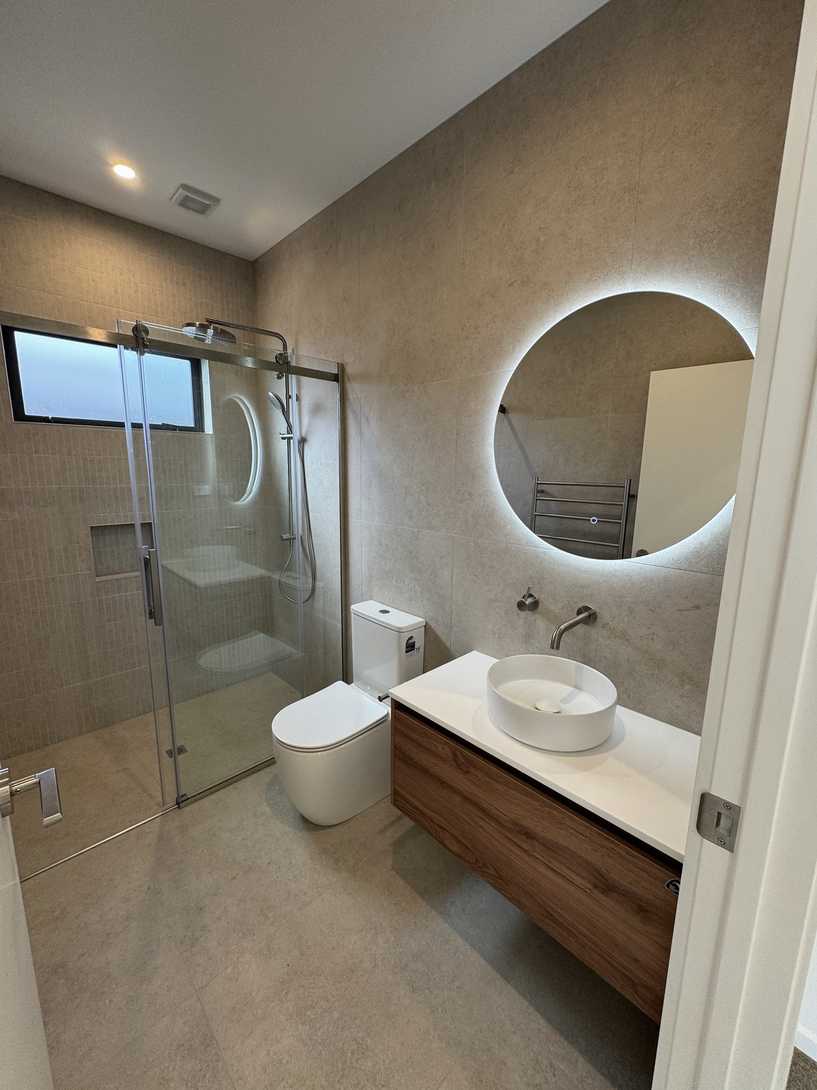 Family bathroom with floating vanity, illuminated mirror, shower and bath