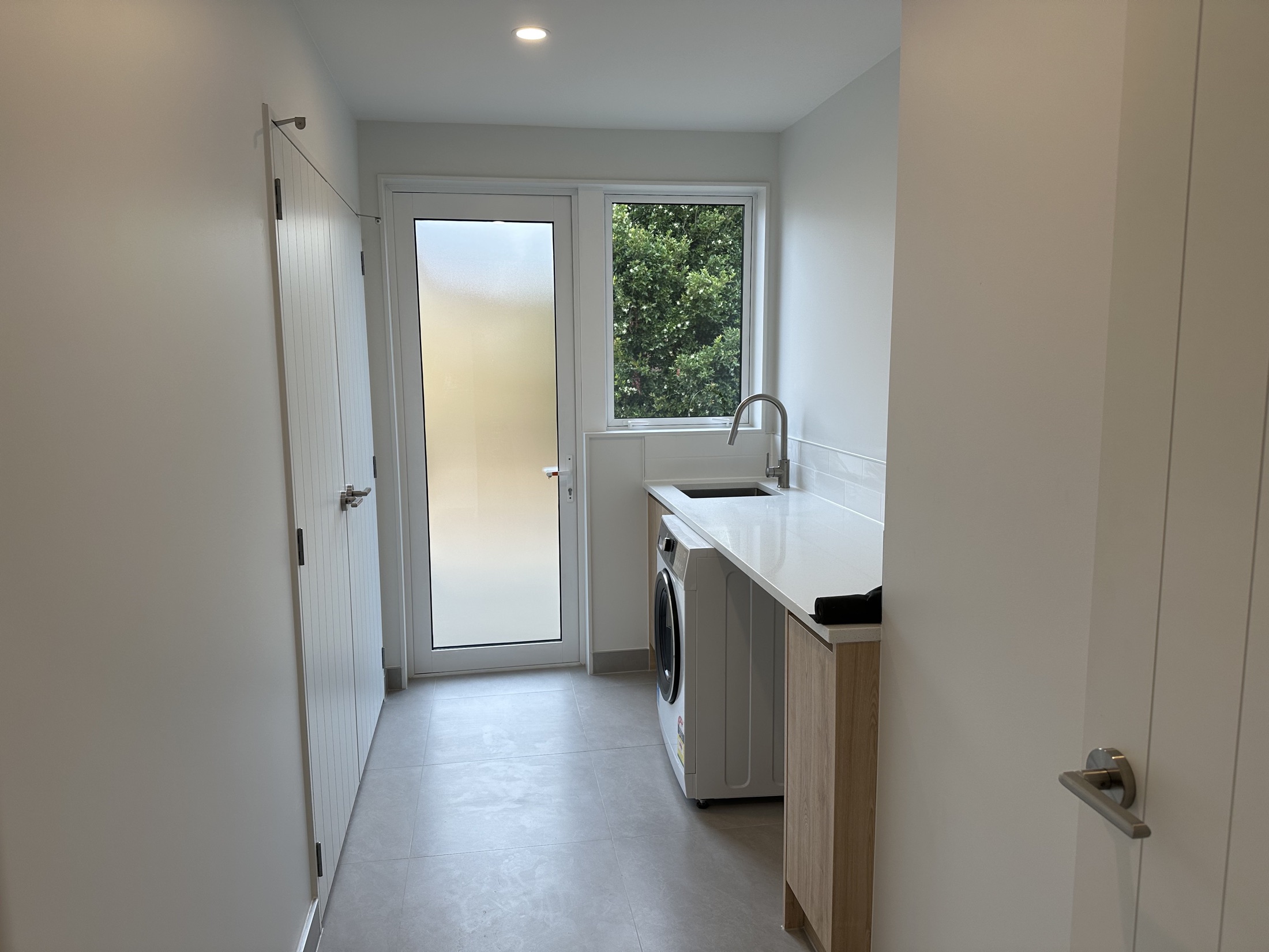 Completed laundry with fitted cabinetry and stainless steel sink